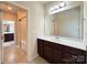 Well-lit bathroom featuring a dark wood vanity, large mirror, and a view into the shower and toilet room at 1281 Arges River Dr, Fort Mill, SC 29715