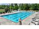 Community pool featuring bright blue water, plenty of lounge chairs, and shaded umbrellas at 1281 Arges River Dr, Fort Mill, SC 29715