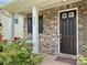 Charming front porch with a dark-colored door, brick accents, and a beautiful landscape at 1281 Arges River Dr, Fort Mill, SC 29715