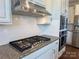 Close-up of a modern kitchen featuring stainless steel appliances and granite countertops with white cabinets at 1281 Arges River Dr, Fort Mill, SC 29715