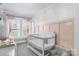 Charming Bedroom with soft pastel tones, featuring a white crib and plenty of natural light for a serene atmosphere at 1300 Nc 90 W Hwy, Taylorsville, NC 28681
