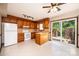Kitchen with white appliances, breakfast bar, wooden cabinets, and sliding door leading to the backyard at 1330 5Th Ne St, Hickory, NC 28601
