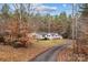 A quaint white home nestled amongst trees, complemented by a paved driveway, lawn, and a small storage shed at 1370 Poole Rd, Salisbury, NC 28146