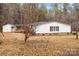 Exterior view showcasing a home with white siding, black shutters, and an adjacent structure with a covered porch at 1370 Poole Rd, Salisbury, NC 28146