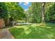 Beautiful backyard with a pool, lush greenery, patio furniture, and mature trees at 14701 Jockeys Ridge Dr, Charlotte, NC 28277