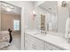 Bathroom with marble vanity, white cabinets, framed mirror, with bedroom in view through doorway at 14701 Jockeys Ridge Dr, Charlotte, NC 28277