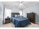 Comfortable bedroom with blue walls, carpet, two windows, ceiling fan, dresser and wooden bed at 14701 Jockeys Ridge Dr, Charlotte, NC 28277