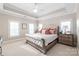 Serene bedroom with neutral carpet, tray ceiling, large windows, and stylish furnishings at 14701 Jockeys Ridge Dr, Charlotte, NC 28277