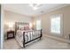 Comfortable bedroom with neutral walls, carpet, two windows, ceiling fan and wrought iron bed at 14701 Jockeys Ridge Dr, Charlotte, NC 28277
