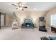 Bonus room featuring a plush blue sofa, large coffee table, ceiling fan, and access to other areas at 14701 Jockeys Ridge Dr, Charlotte, NC 28277