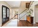 Inviting foyer with hardwood floors, staircase, classic chest, and view into office space at 14701 Jockeys Ridge Dr, Charlotte, NC 28277