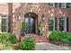Elegant brick home entrance with a double door, arched entryway, and manicured landscaping at 14701 Jockeys Ridge Dr, Charlotte, NC 28277