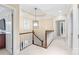 Upstairs hallway featuring neutral carpet, classic chandelier, and views of other rooms at 14701 Jockeys Ridge Dr, Charlotte, NC 28277