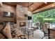 Inviting covered patio with a stone fireplace, TV, fan and comfortable lounge seating overlooking a pool at 14701 Jockeys Ridge Dr, Charlotte, NC 28277