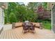 Back deck featuring a grill, stone accents, outdoor furniture, and lush landscaping at 157 Dedham Loop, Mooresville, NC 28117