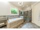 Luxurious bathroom features a soaking tub, glass-enclosed shower, and elegant tile work at 157 Dedham Loop, Mooresville, NC 28117