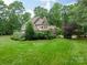 Large home with stone chimney, lush lawn, and mature landscaping at 157 Dedham Loop, Mooresville, NC 28117
