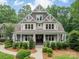 Charming two-story home with a welcoming front porch, lush landscaping, and classic architectural details at 157 Dedham Loop, Mooresville, NC 28117