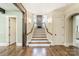 Elegant foyer with hardwood floors and a staircase featuring stone accents and decorative lighting at 157 Dedham Loop, Mooresville, NC 28117
