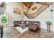 Inviting living room with a leather sectional sofa, hardwood floors, and staircase to the upper level at 157 Dedham Loop, Mooresville, NC 28117