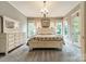 Bright main bedroom features a king-sized bed, neutral decor, and access to a private balcony at 157 Dedham Loop, Mooresville, NC 28117