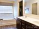 Bathroom with dual sink vanity, dark cabinetry, and a separate soaking tub at 161 Old Harbor Dr, Mount Gilead, NC 27306