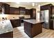 Modern kitchen with dark wood cabinets, stainless steel appliances, and granite countertops, plus central island at 161 Old Harbor Dr, Mount Gilead, NC 27306