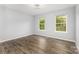 Bedroom with neutral walls and flooring receives natural light from two windows at 2112 Flint Glenn Ln, Charlotte, NC 28262