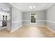 Dining room with tan tiled floor, chair rail, chandelier, and an open entrance to kitchen at 2112 Flint Glenn Ln, Charlotte, NC 28262