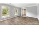 Bright living room featuring wood-look flooring, neutral walls, and natural light from two windows at 2112 Flint Glenn Ln, Charlotte, NC 28262