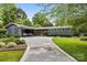 Charming gray single-story home featuring a concrete driveway, landscaped front yard, and a unique carport at 2121 Valencia Ter, Charlotte, NC 28226