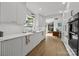 Modern kitchen with white cabinetry, marble countertops, stainless steel appliances, and hardwood floors at 2121 Valencia Ter, Charlotte, NC 28226