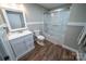 Clean bathroom featuring white vanity, enclosed shower, and wood-look flooring at 24264 Strand Dr, Albemarle, NC 28001