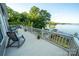 Spacious outdoor deck with seating and a picturesque lake view. Perfect for entertaining and relaxation at 24264 Strand Dr, Albemarle, NC 28001