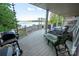 Covered deck with seating, a grill, and a serene lake view. Perfect for outdoor dining and relaxation at 24264 Strand Dr, Albemarle, NC 28001