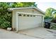 Detached two car garage with white door, adjacent to driveway and partial view of yard at 24264 Strand Dr, Albemarle, NC 28001