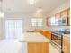 Bright kitchen with wood cabinets, stainless appliances, island and sliding door leading to the backyard at 2802 Azalea Hills Dr, Charlotte, NC 28262