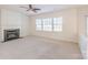 Bright living room with fireplace, ceiling fan, and large windows offering plenty of natural light at 2802 Azalea Hills Dr, Charlotte, NC 28262