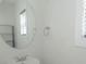 Modern bathroom with a circular mirror, chrome fixtures, and bright natural light at 2908 Burgess Dr, Charlotte, NC 28208
