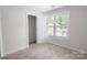 Bedroom with neutral walls, carpet, closet space and a large window for natural light at 2908 Burgess Dr, Charlotte, NC 28208