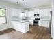 Bright kitchen featuring white cabinets, granite countertops, stainless appliances, and modern lighting at 2908 Burgess Dr, Charlotte, NC 28208