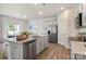 Open floor plan of kitchen, dining and living areas with stainless appliances and hardwood style flooring at 3019 Sassafras Trl, Gastonia, NC 28056