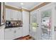 Bright kitchen area boasting white cabinets, a tiled backsplash, granite countertops, and an exterior door at 314 Euclid Ave, Statesville, NC 28677
