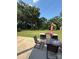 This outdoor patio features a glass table, chairs, umbrella, and grill, with a lush green yard in the background at 314 Euclid Ave, Statesville, NC 28677