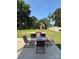 A outdoor patio includes a glass table, chairs, umbrella, and grill that is surrounded by a lush green yard at 314 Euclid Ave, Statesville, NC 28677
