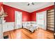 Cozy bedroom features a red accent wall, hardwood floors, and ample natural light from two windows at 319 S Oakland St, Gastonia, NC 28052