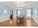 Dining room boasts coffered ceilings, hardwood floors, wainscoting and neutral blue walls at 319 S Oakland St, Gastonia, NC 28052