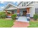 Charming home featuring a welcoming front porch with wood columns, brick walkway, and well-manicured lawn at 319 S Oakland St, Gastonia, NC 28052