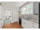 Charming kitchen featuring white cabinets, granite countertops, and stainless steel appliances, with a laundry area visible nearby at 319 S Oakland St, Gastonia, NC 28052