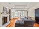 Open living room with hardwood floors, fireplace, tray ceiling, and a comfortable gray sectional sofa near French doors at 319 S Oakland St, Gastonia, NC 28052